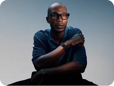 A man sitting and thinking while wearing clear Ray-Ban metaglasses.